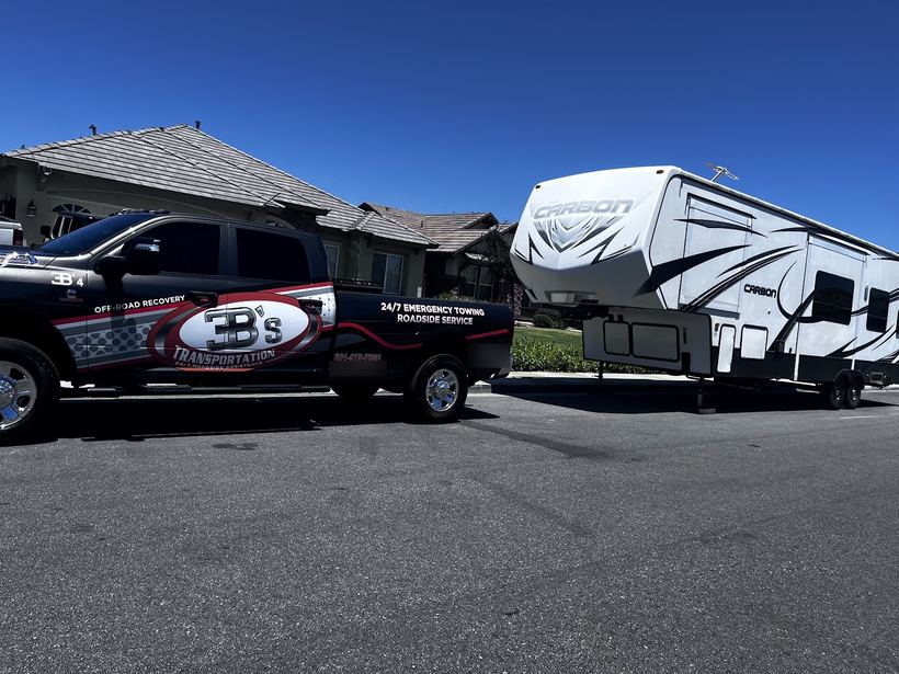 3B's wrapped pickup next to a white Carbon fifth-wheel trailer